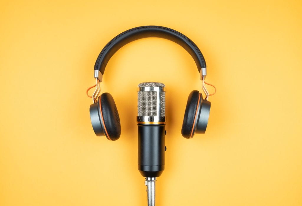 Headphones and microphone on a yellow background.